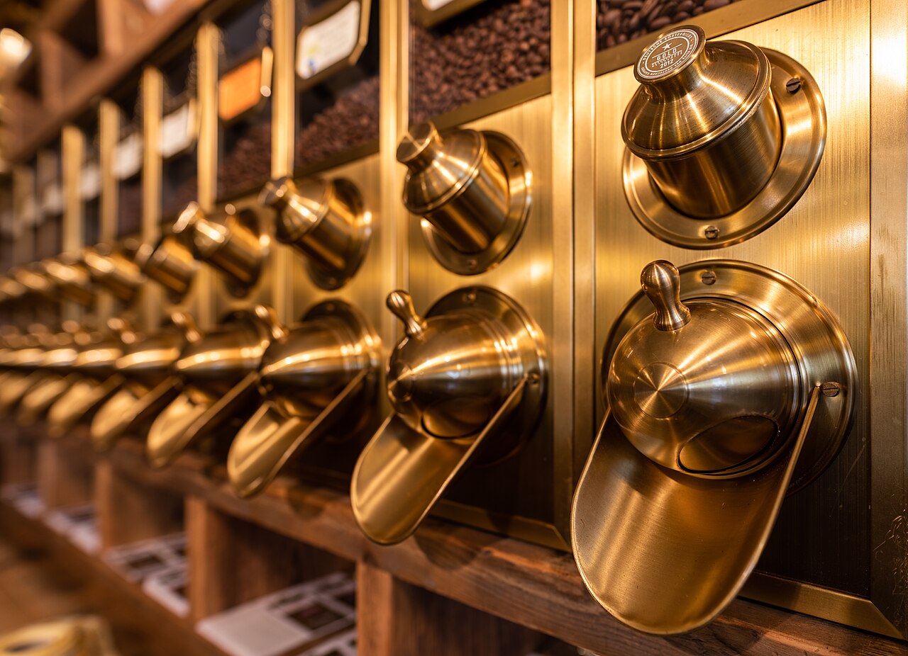 Close-up of brass coffee scoops and bean bins